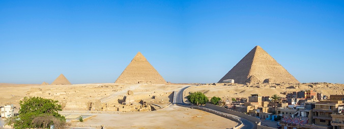 Gizeh, Egypt - 05 20th, 2019 : This photo was taken in Egypt, in Giza towards the capital Cairo. It shows a Panorama of the three great Pyramids of Egypt.