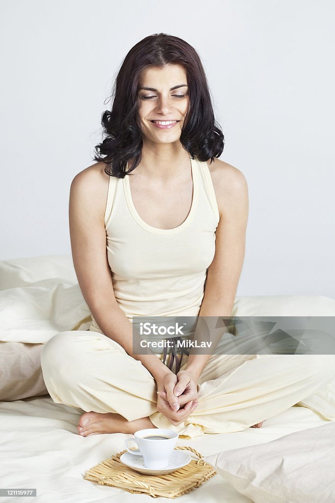Morning relaxation Pretty young brunette woman mediating in bed Adult Stock Photo