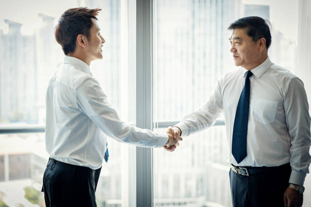 istock Two Asian businessmen shaking hands 1211161185