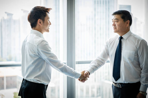 istock Two Asian businessmen shaking hands 1211161194