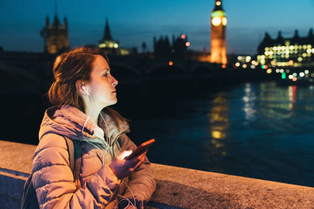 istock Student in UK using smartphone outside at night 1211163435