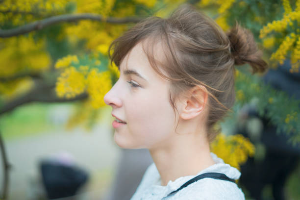 istock A woman watching mimosa blossoms 1211163493