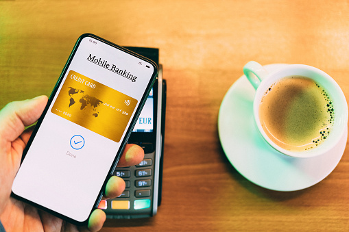 Man in cafe paying contactless with smart phone