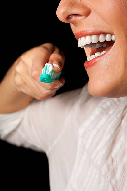 istock Woman teeth cleaning on black background 121116799