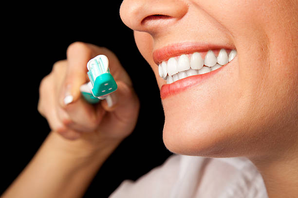 istock Woman teeth cleaning on black background 121116803