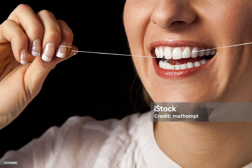 Mujer dientes limpieza sobre fondo negro - Foto de stock de Fondo negro libre de derechos