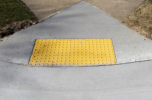 Sidewalk curb ramp with bumpy anti slip pad.