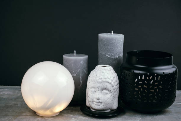 istock gray candles and white  ceramic Buddha head on a table opposite black wall 1211170403