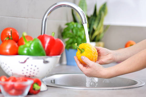 istock Washing vegetables. A woman in the kitchen. 1211170594