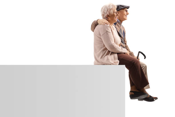 istock Profile shot of an elderly couple sitting on a blank panel in embrace 1211171521