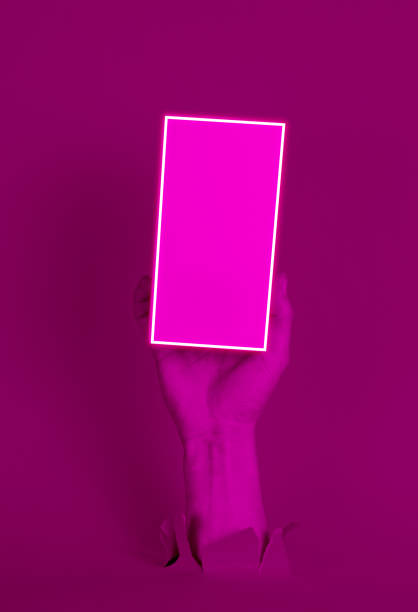 istock Female hand holds white box through torn paper with neon light 1211171971