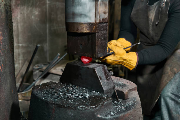 istock female hands processes a red hot workpiece with a power hammer 1211172039