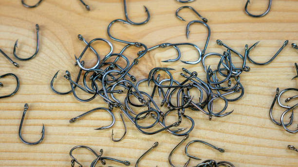 istock Fishing hooks on wooden background 1211172679