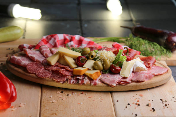 Wooden charcuterie board with meat and cheese Antipasto appetizer platter with ham, salami, olive, brie cheese, goat cheese - Top view stock photo appetizer plate stock pictures, royalty-free photos & images