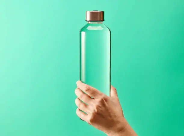 Photo of Refillable drinking water bottle on mint green background