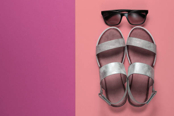 istock Creative summer beach flat lay. Leather women's sandals, sunglasses on colored background. Top view 1211173343