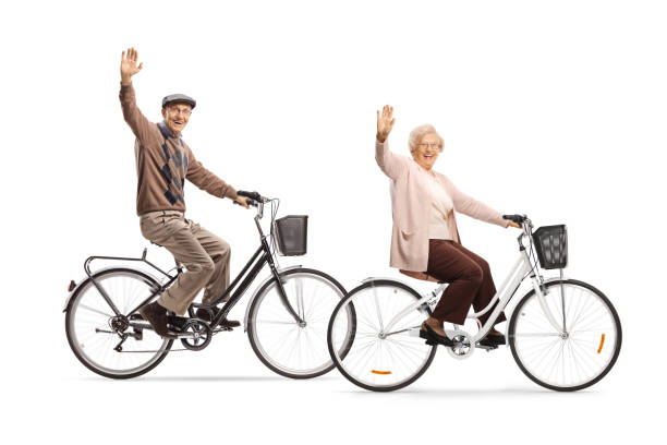 istock Seniors riding bicycles and waving at the camera 1211174315