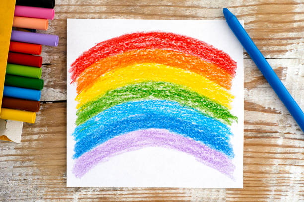 istock Hand drawing Rainbow with wax crayons. Wooden background. 1211174590