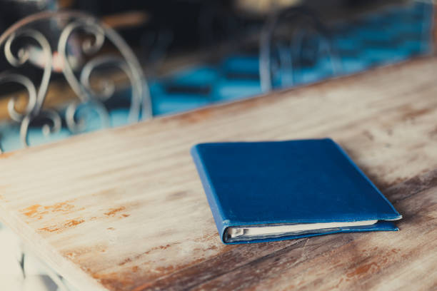 old blue book on the wooden desk. - book photo album publication open imagens e fotografias de stock