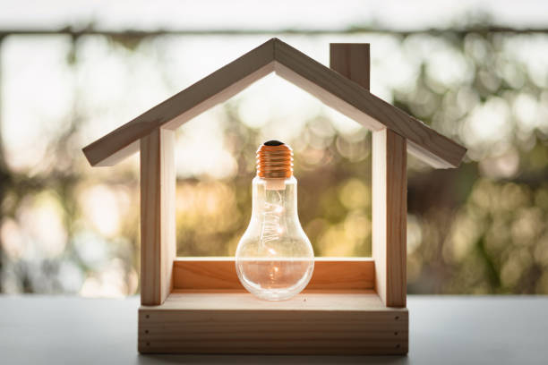 istock Light bulb with wood house on the table, a symbol for construction, Creative light bulb idea, power energy or business idea concept ecology, loan, mortgage, property or home. 1211174650