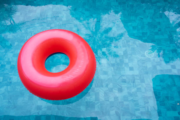 istock Red pool float, ring floating in a refreshing blue swimming pool with shadow of coconut tree. Copy space, summer vacation concept. 1211174725