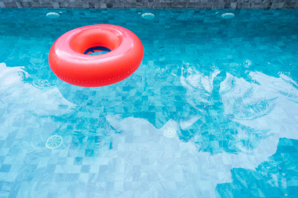 istock Red pool float, ring floating in a refreshing blue swimming pool with shadow of coconut tree. Copy space, summer vacation concept. 1211174733