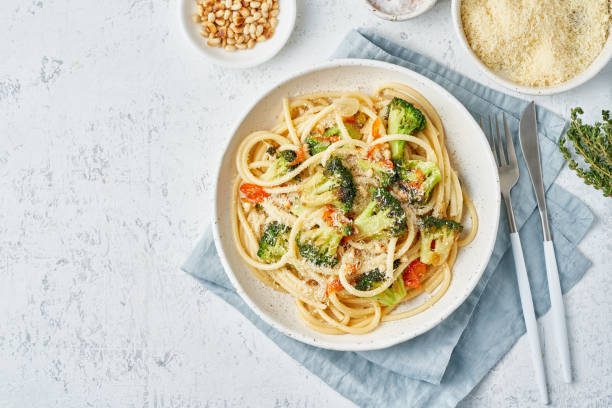 istock Spaghetti pasta with broccoli, bucatini with peppers, garlic, pine nuts. Top view, copy space 1211178920