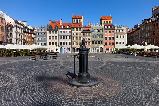 City of Warsaw in Poland, Old Town Market Square, picturesque houses and vintage water pump.