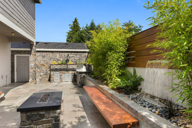 Home exterior backyard hardscape entertainment area with fire pit, bench seating, water feature and barbecue Backyard hardscape entertainment area hardscape photos stock pictures, royalty-free photos & images