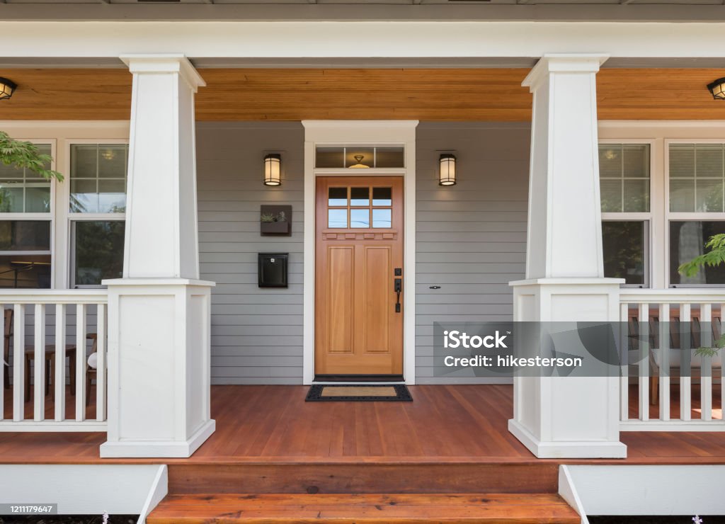 Covered porch and front door of beautiful new home Facade of home with covered porch and door House Stock Photo