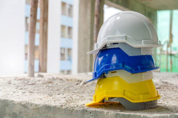 istock white, blue and yellow hard safety helmet for safety accident stack on floor at workplace in construction site building background, safety first, contractor business, industry and construction concept 1211181035