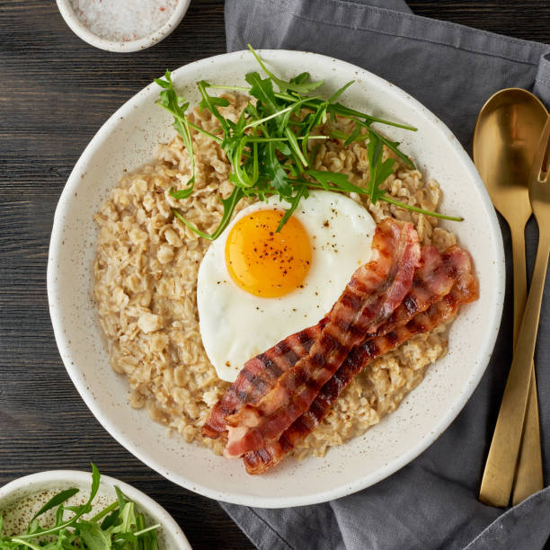 istock Oatmeal, fried egg and fried bacon. Brutal man sport breakfast. Hearty fat breakfast. Macro 1211183158