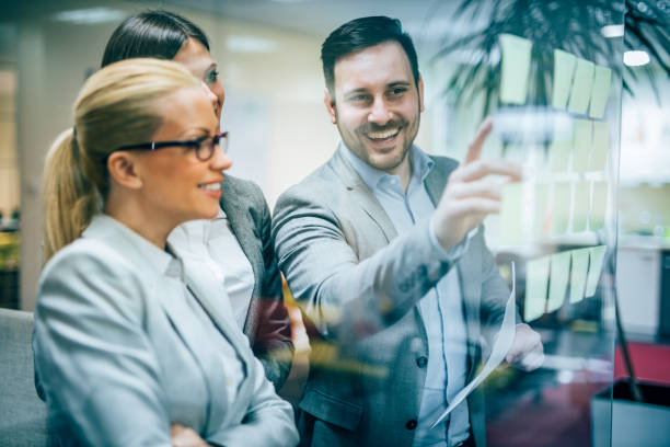 istock Colleagues brainstorming with sticky notes on glass wall. 1211185924