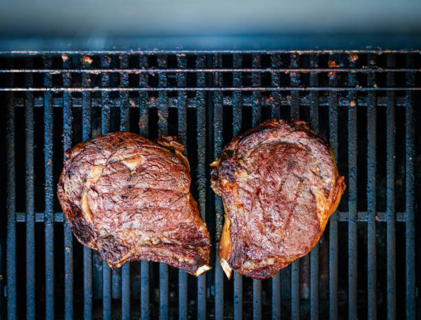 Bone in rib-eyes resting on the grill