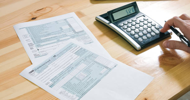 istock Person filling US tax form 1211187183