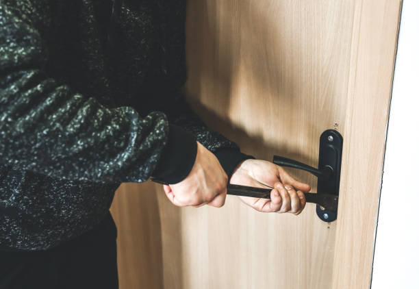 istock Criminal with crowbar near the doors. Robber breaking into house. 1211187949