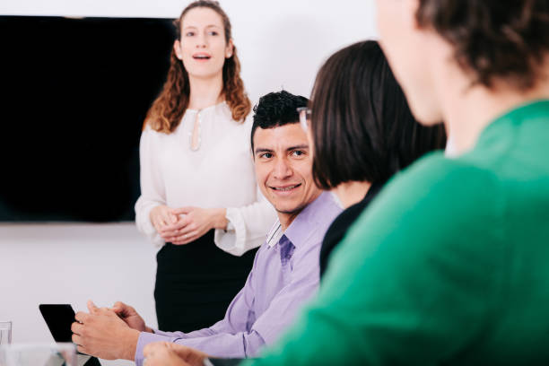 istock Group of office workers at a meeting around the boss 1211189946