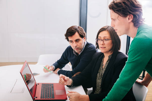 istock Group of office workers at a meeting around the boss 1211190009