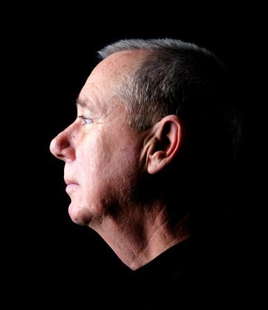 Profile of a senior man with a black background. Same model: