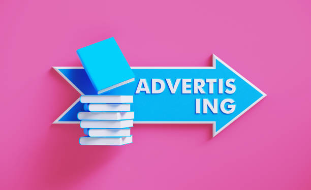 istock Book Stack Sitting over A Blue Arrow Shaped Directional Sign on Pink Background 1211191562