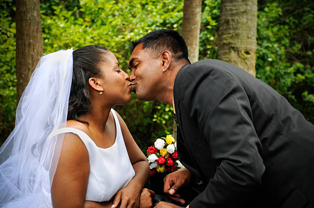 diversi coppia condividendo un bacio di nozze - couple black american culture kissing foto e immagini stock