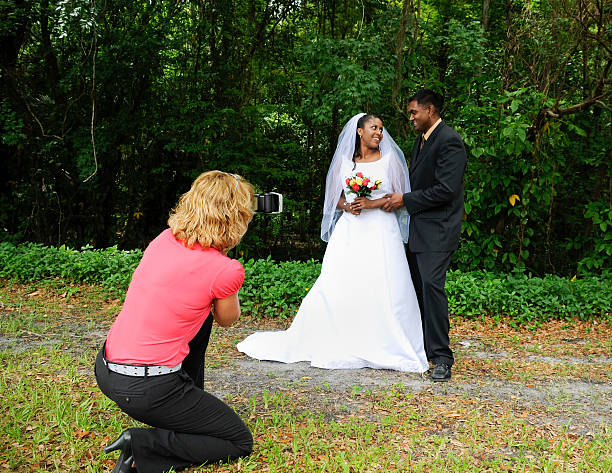 frau fotograf fotografieren verschiedenen hochzeitspaar - wedding african descent american culture bride stock-fotos und bilder