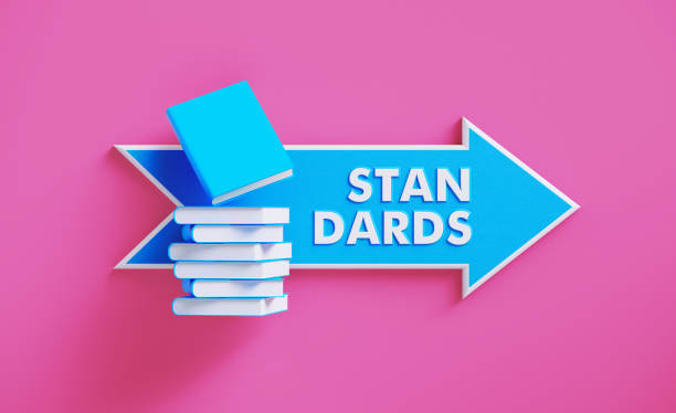istock Book Stack Sitting over A Blue Arrow Shaped Directional Sign on Pink Background 1211192558