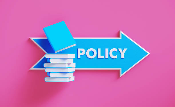 istock Book Stack Sitting over A Blue Arrow Shaped Directional Sign on Pink Background 1211192717