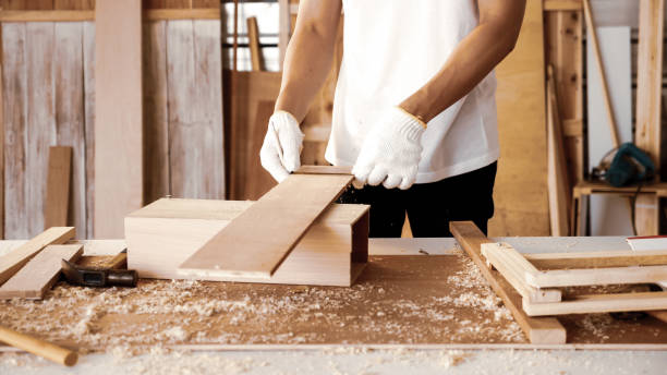 istock Carpenter holding pieces of board at site. 1211195851