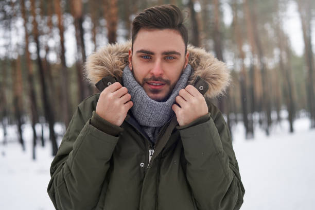 istock Attractive bearded man standing outdoors in winter season forest. 1211197394