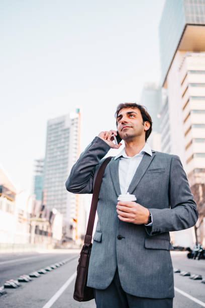 istock Smiling businessman talking by phone 1211198997