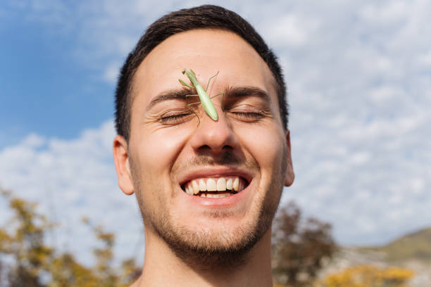 istock Cheerful hiker with a praying mantis on his ear 1211200160