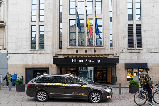 Antwerp / Belgium - October 08 2019: The entrance of the Hilton Hotel in Antwerp city with a taxi car waiting in front of the door