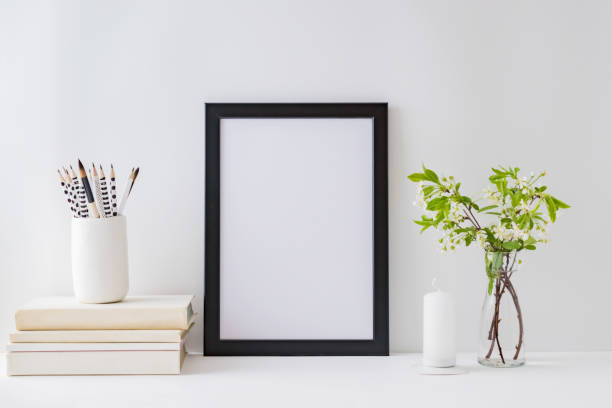 istock Home interior with decor elements. Mockup with a black frame, spring flowers in a vase on a light background 1211201505